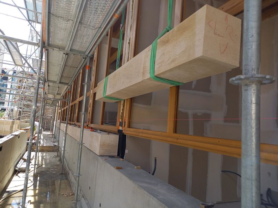 Pose d'un bloc de pierre de taille sur échafaudage, chantier Batipose